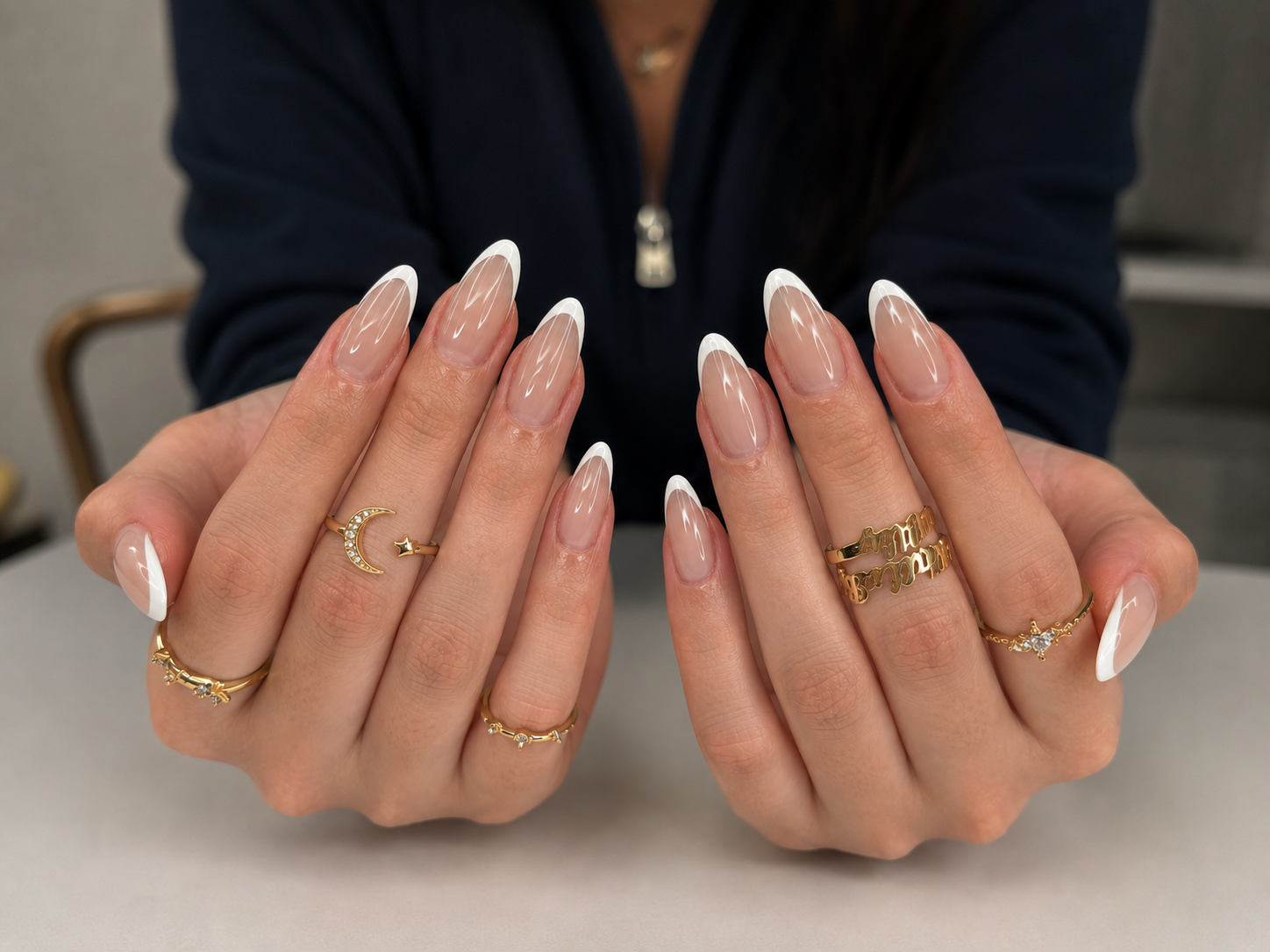 A close-up of a person's hands with long French-tip manicured nails.