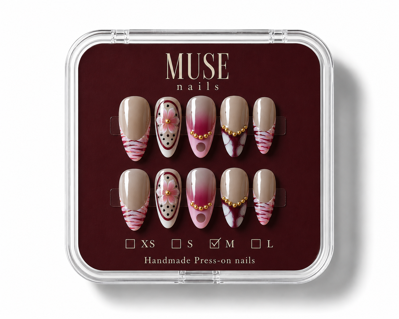 MUSE nails brand hand-made press-on nails in a clear plastic clamshell case with a dark burgundy insert. The nails feature a beige base with pink and white striped, polka dot, and floral designs.