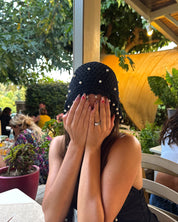 A woman sitting at an outdoor patio table with pink floral motif nails nail art